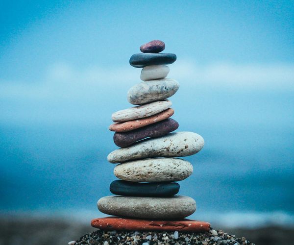 Stack of balanced stones on a calm beach shore.